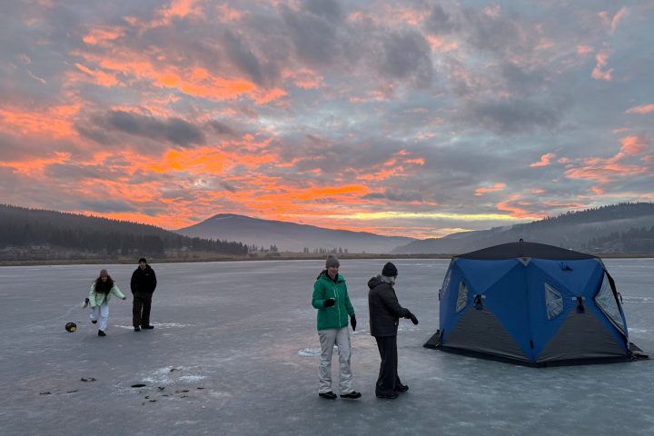 a group of people standing next to a body of water