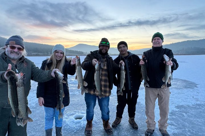 a group of people standing next to a lake