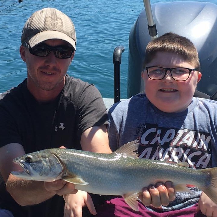a man holding a fish on a boat