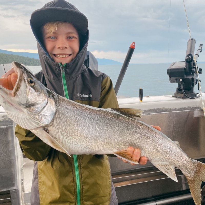 a person holding a fish on a boat