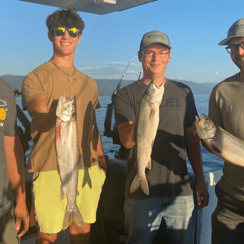 a couple of people standing next to a person holding a fish