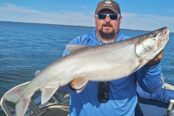 a man holding a fish in the water